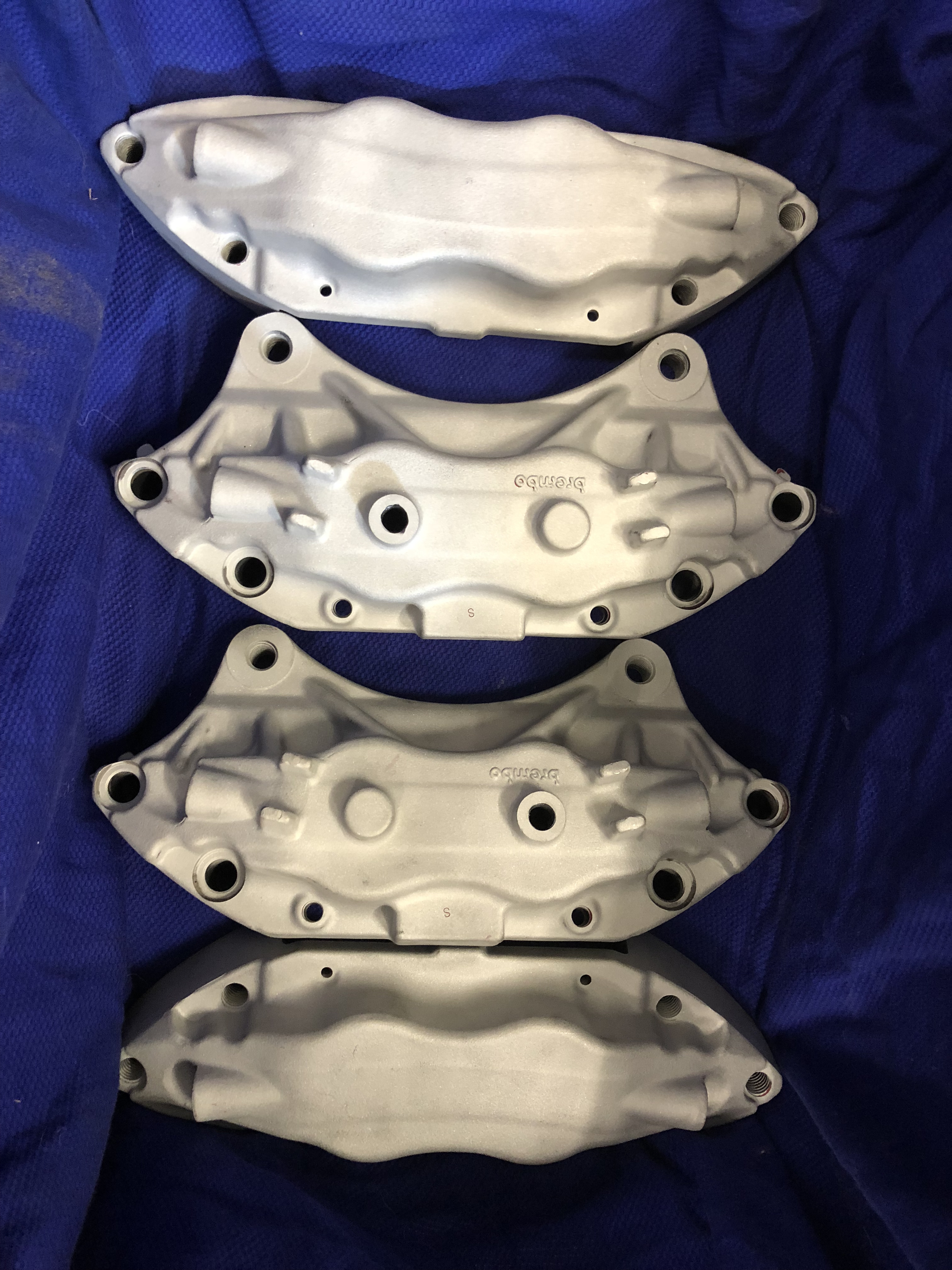 Brake calipers after blasting — raw aluminium ready for powder coat